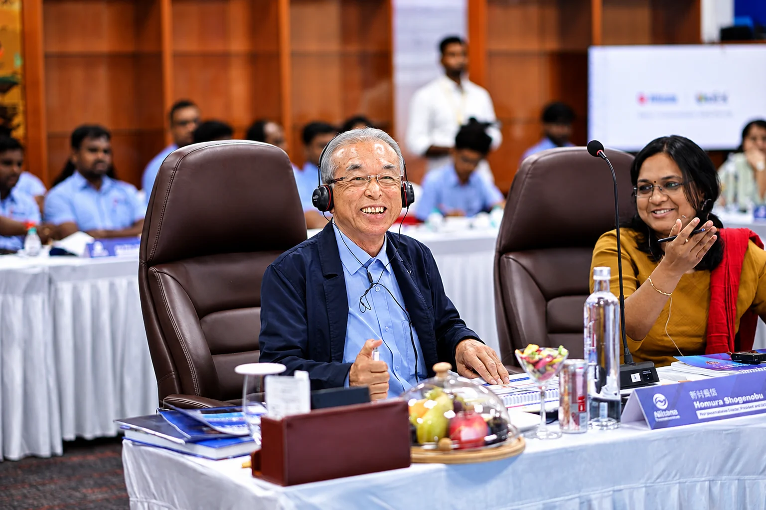 Delegate wearing interpretation headset laughs during a boardroom session